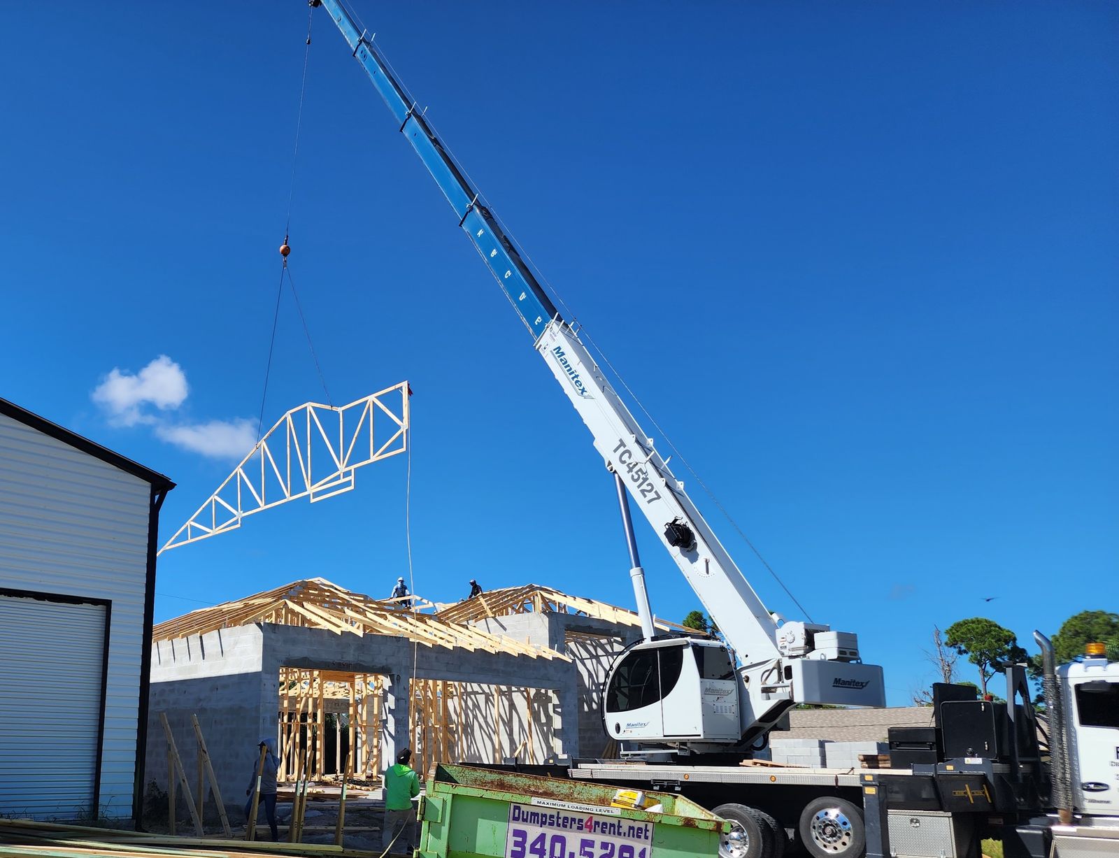 Crane setting roof trusses on an M&M Builds new home